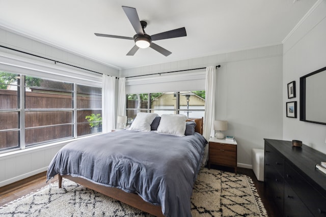 bedroom featuring ornamental molding, ceiling fan, wood finished floors, and multiple windows