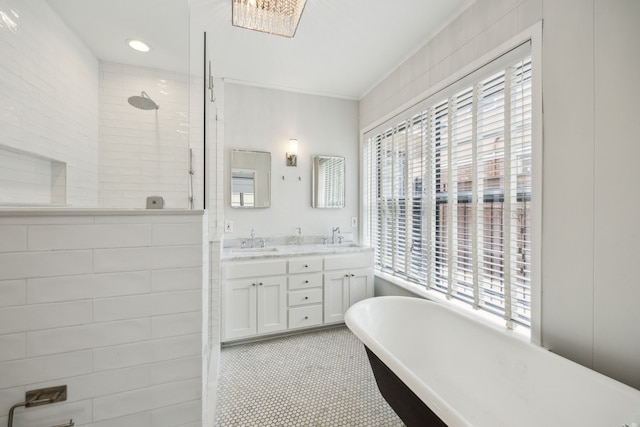 bathroom with double vanity, a sink, a walk in shower, and a soaking tub