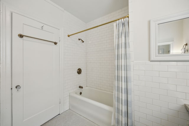 bathroom with tile patterned floors, wainscoting, tile walls, and shower / tub combo with curtain