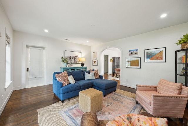 living room with arched walkways, baseboards, recessed lighting, and wood finished floors
