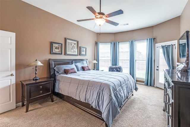 bedroom featuring ceiling fan, light colored carpet, access to exterior, and visible vents