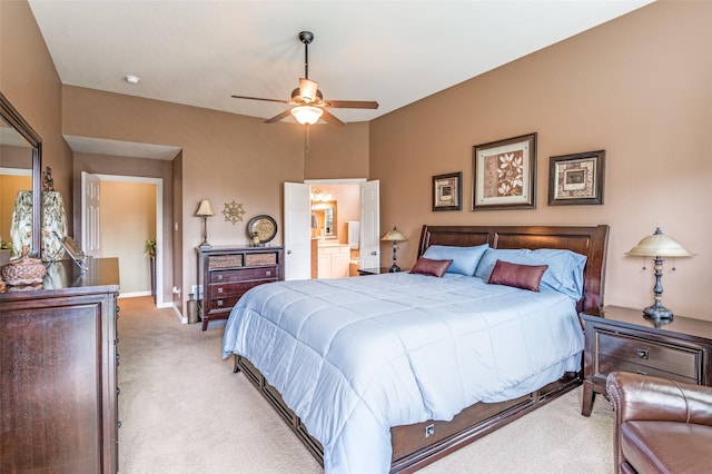 bedroom featuring light colored carpet, a ceiling fan, baseboards, and ensuite bath