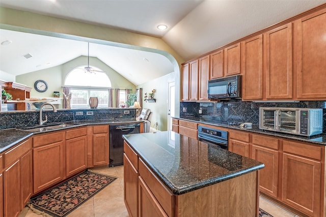 kitchen with decorative backsplash, a sink, a toaster, black appliances, and lofted ceiling