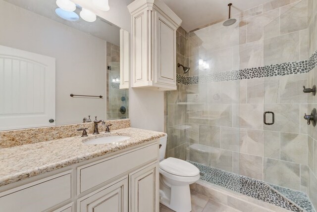 bathroom with vanity, toilet, tile patterned flooring, and a stall shower