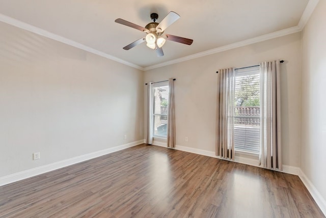 empty room with crown molding, ceiling fan, a wealth of natural light, and wood finished floors