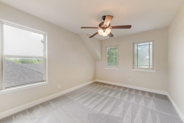 unfurnished room with light colored carpet, a ceiling fan, and baseboards