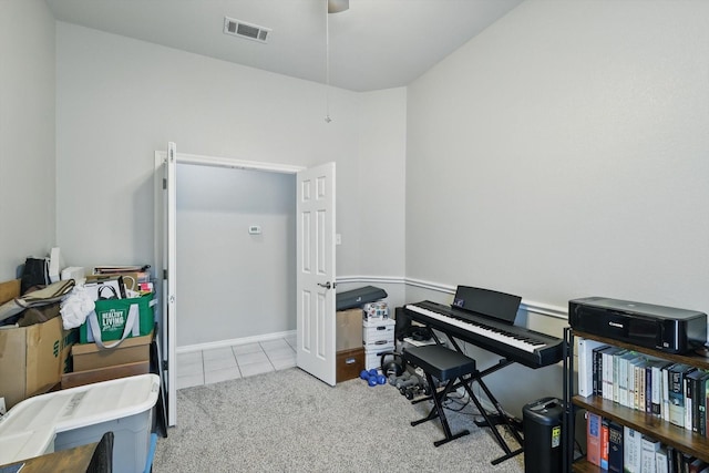 carpeted office space featuring tile patterned flooring, a ceiling fan, and visible vents