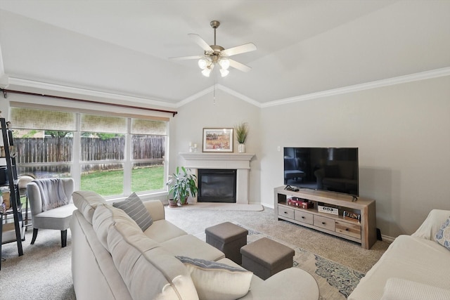 living room with ceiling fan, crown molding, lofted ceiling, a glass covered fireplace, and carpet