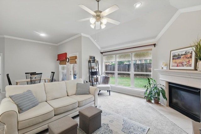living area with crown molding, vaulted ceiling, a ceiling fan, and a premium fireplace