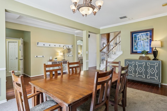 dining area featuring ornamental molding, wood finished floors, baseboards, stairway, and a chandelier