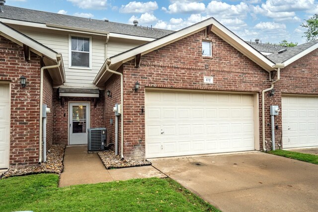 172 High School Dr, Lewisville, TX 75057 - view of front of house with roof with shingles, central AC, brick siding, a garage, and concrete driveway