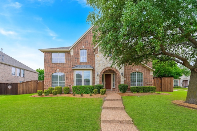 view of front facade featuring brick siding, a front lawn, and fence