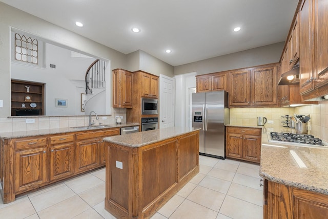2131 Channel Islands Dr, Allen, TX 75013 - kitchen featuring brown cabinets, appliances with stainless steel finishes, a sink, under cabinet range hood, and a kitchen island