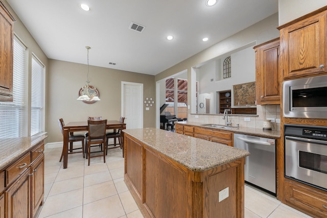 2131 Channel Islands Dr, Allen, TX 75013 - kitchen with a sink, brown cabinets, a kitchen island, and stainless steel appliances