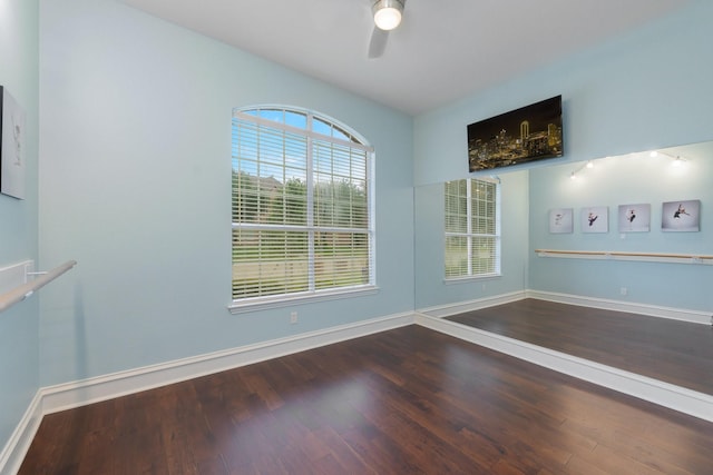 empty room featuring a ceiling fan, baseboards, and wood finished floors