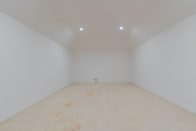 unfurnished room with light carpet, recessed lighting, and lofted ceiling
