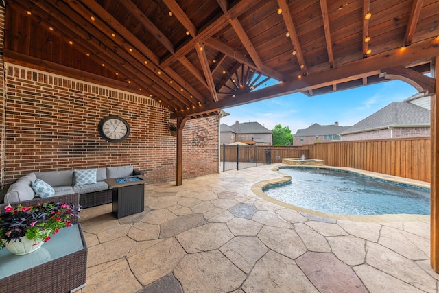 view of swimming pool with a fenced backyard, a pool with connected hot tub, a patio area, and outdoor lounge area