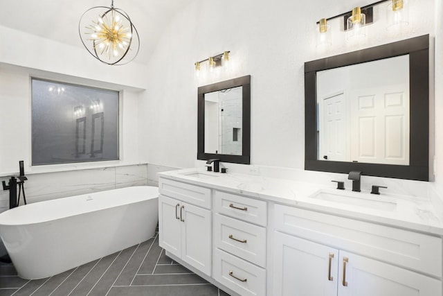bathroom with double vanity, a soaking tub, a sink, and lofted ceiling
