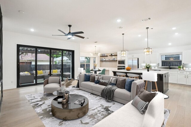living area with recessed lighting, visible vents, ceiling fan with notable chandelier, and light wood-type flooring
