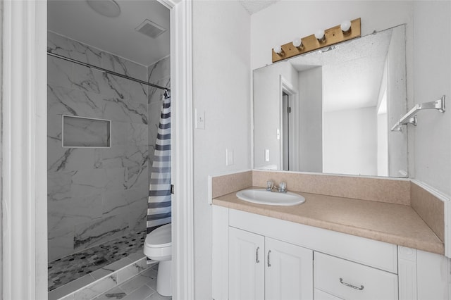 bathroom featuring toilet, visible vents, a shower stall, and vanity