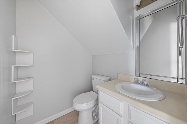 bathroom featuring vanity, baseboards, toilet, and wood finished floors