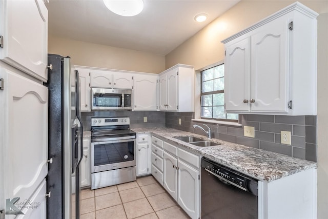 kitchen with a sink, white cabinetry, appliances with stainless steel finishes, and backsplash