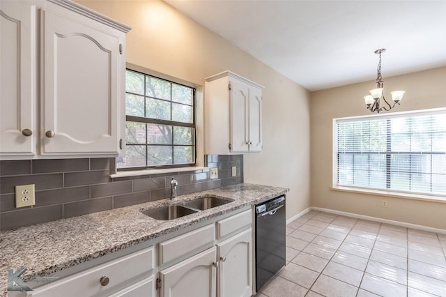 kitchen with tasteful backsplash, a sink, baseboards, black dishwasher, and white cabinetry