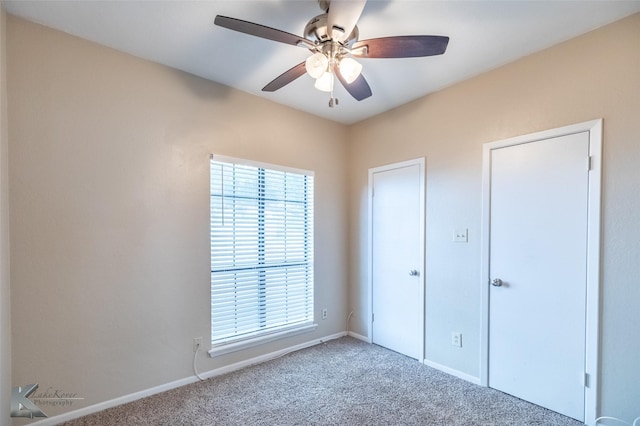 unfurnished bedroom featuring carpet floors, baseboards, and multiple windows