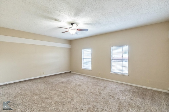 spare room featuring carpet floors, baseboards, a ceiling fan, and a textured ceiling