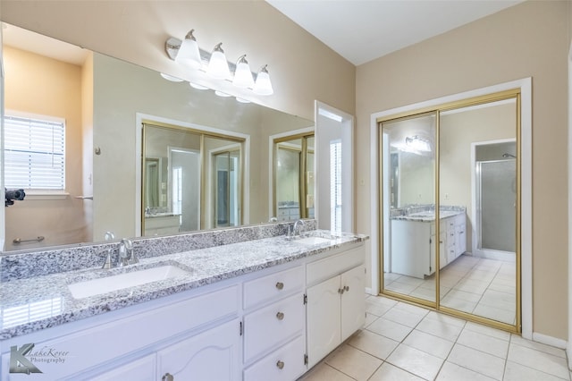 full bathroom with a sink, tile patterned floors, a shower with door, and double vanity