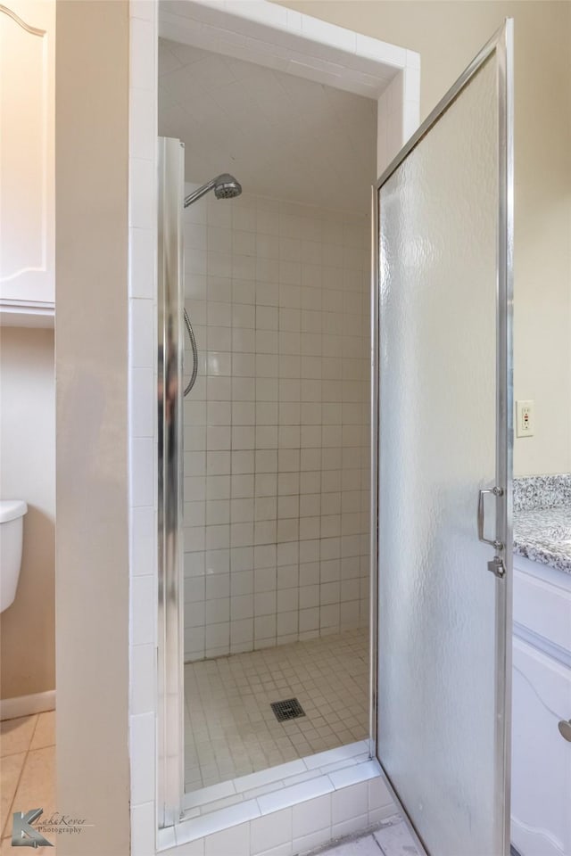 full bath featuring tile patterned floors and a shower stall