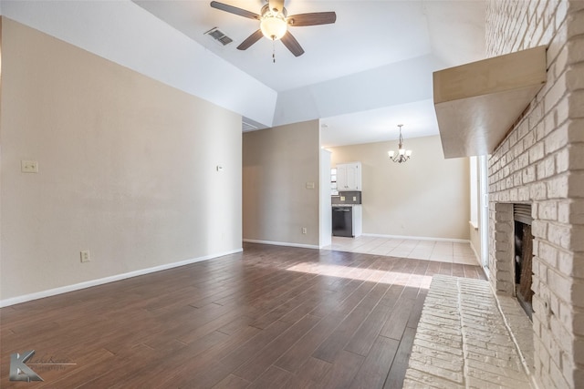 unfurnished living room with visible vents, a fireplace, ceiling fan with notable chandelier, lofted ceiling, and light wood-style flooring