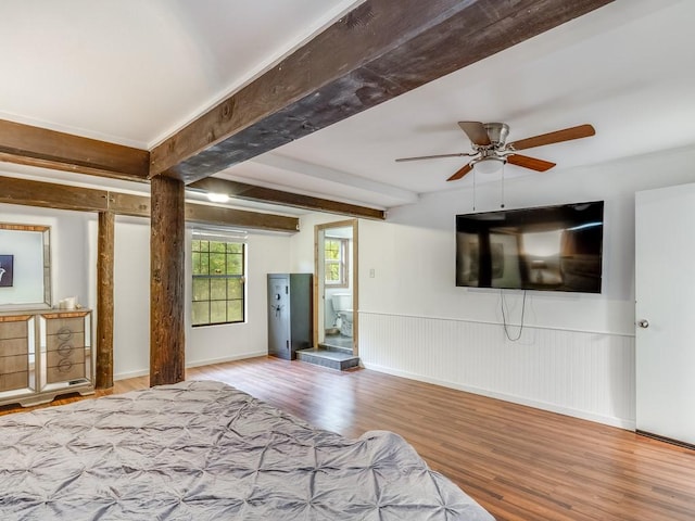 bedroom with baseboards, a ceiling fan, wood finished floors, and beamed ceiling