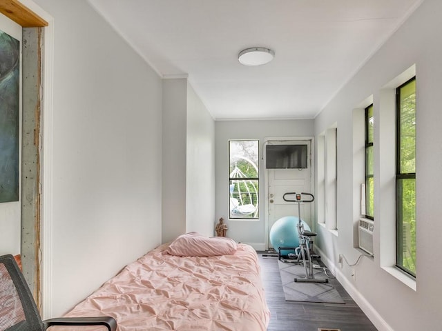 bedroom featuring baseboards, ornamental molding, and wood finished floors