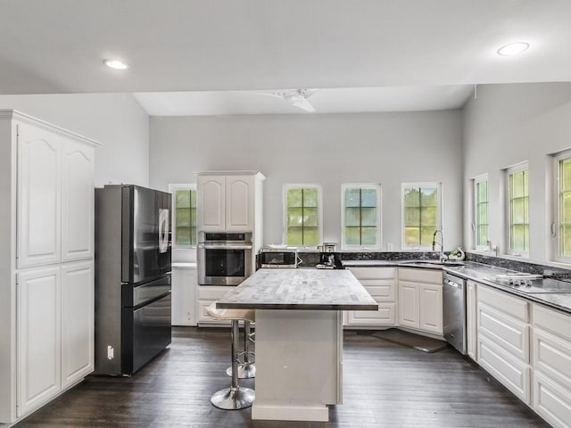 kitchen featuring white cabinetry, appliances with stainless steel finishes, a kitchen island, and a kitchen breakfast bar
