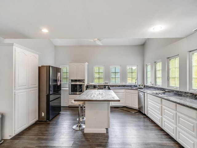 kitchen with white cabinets, stainless steel appliances, a sink, and a wealth of natural light