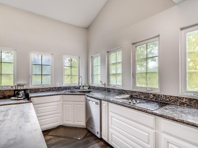 kitchen with stainless steel dishwasher, vaulted ceiling, a sink, white cabinets, and black electric stovetop