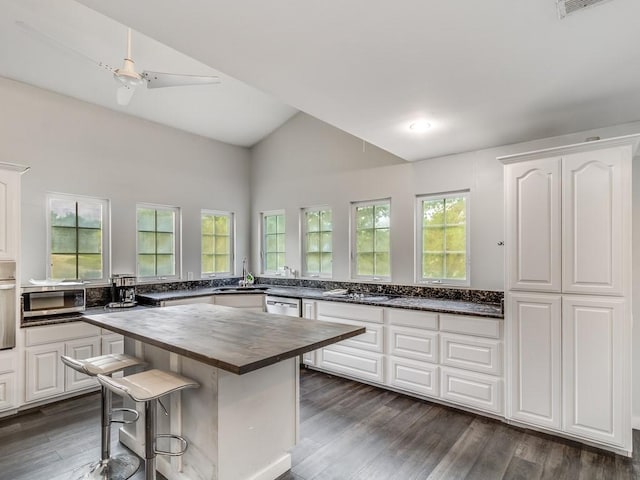 kitchen with butcher block countertops, a sink, dark wood finished floors, and white cabinets