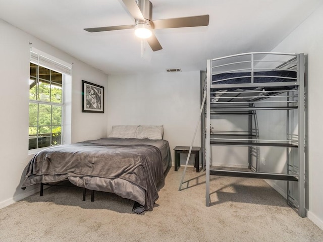 carpeted bedroom with a ceiling fan, baseboards, and visible vents