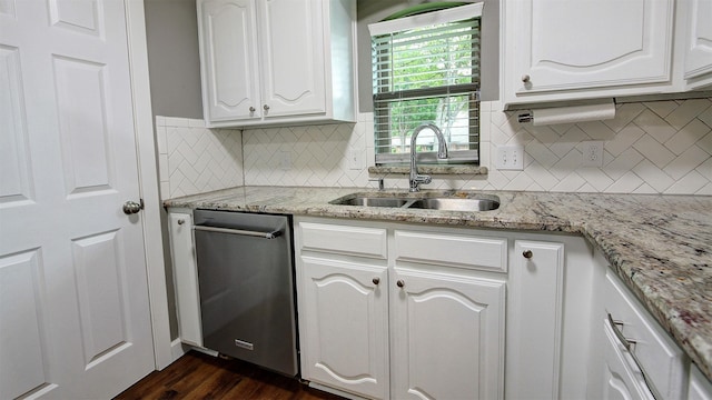 kitchen featuring dark wood-style flooring, tasteful backsplash, dishwasher, a sink, and white cabinetry