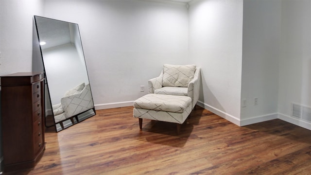 living area featuring baseboards, wood finished floors, and visible vents