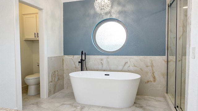 full bath with toilet, tile walls, a soaking tub, and marble finish floor