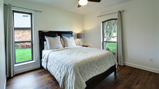 bedroom with baseboards, ceiling fan, and dark wood-type flooring