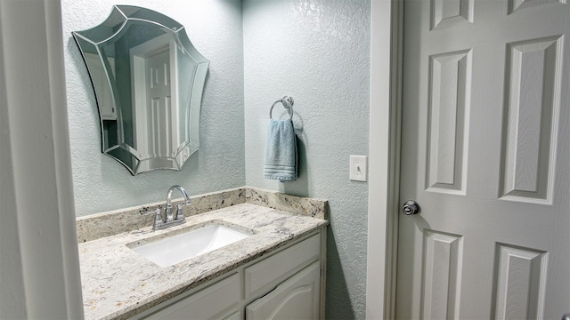 bathroom with vanity and a textured wall