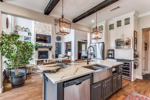 kitchen with visible vents, a sink, beverage cooler, open floor plan, and stainless steel appliances