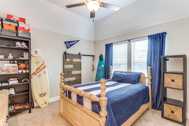 bedroom featuring a ceiling fan, a barn door, light carpet, and baseboards