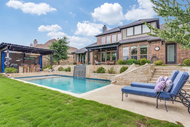 rear view of house with a pergola, an outdoor pool, a chimney, a patio area, and a yard