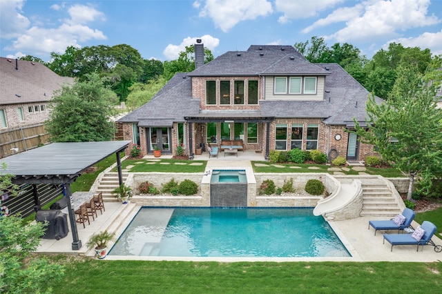 back of house with a pergola, a chimney, stairs, brick siding, and a yard