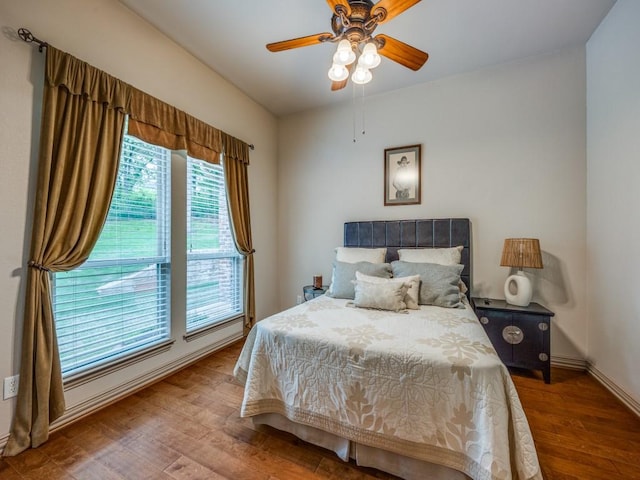 bedroom featuring baseboards, a ceiling fan, and wood finished floors