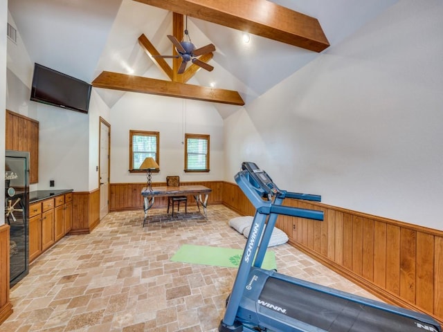 workout room with visible vents, wooden walls, high vaulted ceiling, a wainscoted wall, and a ceiling fan